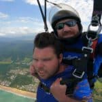 two men skydiving over a beach