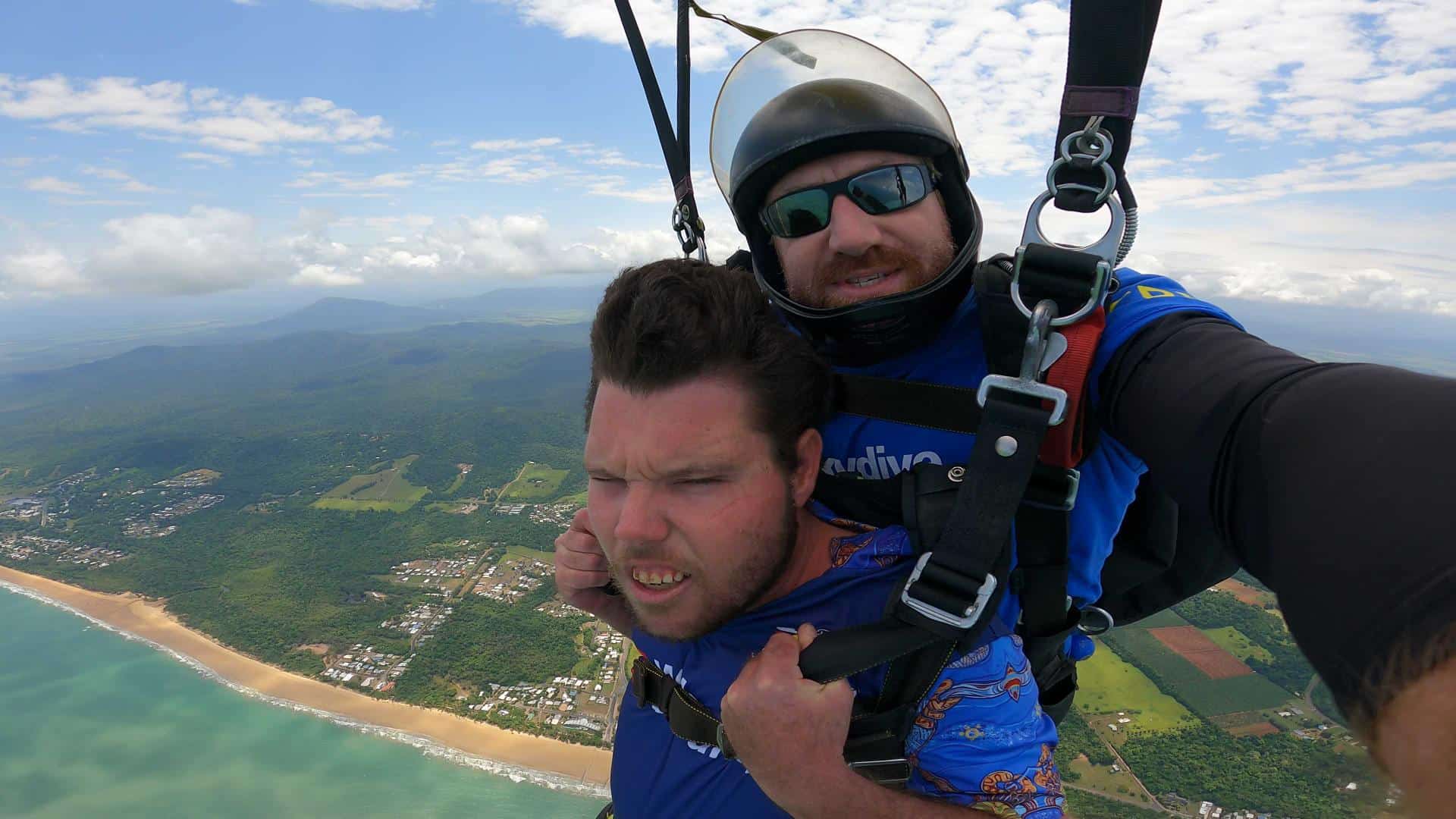 two men skydiving over a beach